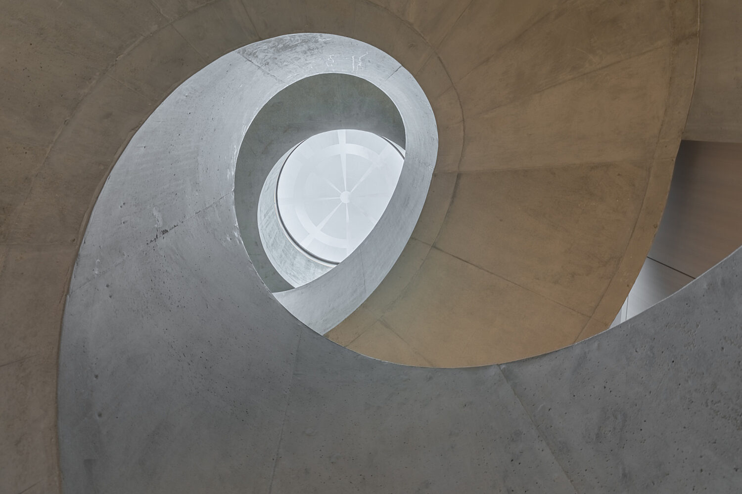 Spiral concrete staircase with skylight